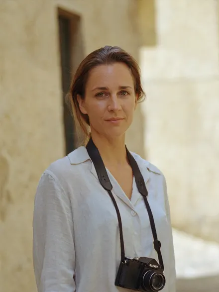 A traveller with a camera round her neck in an old town