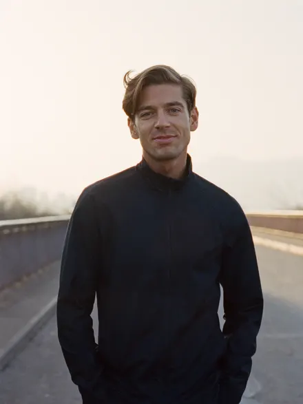 A man in a dark jacket on a quiet road