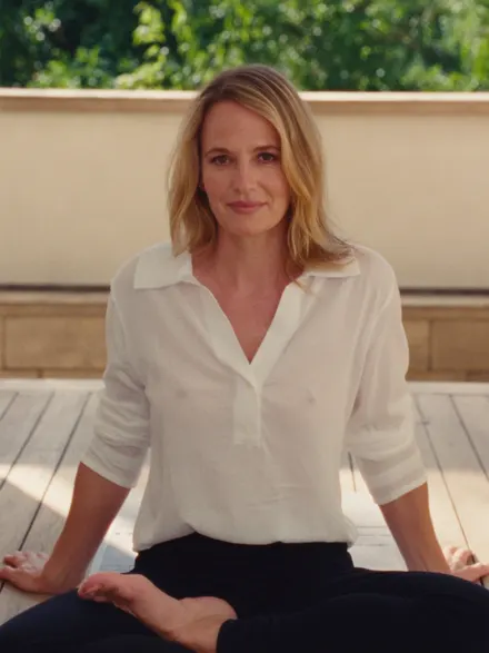 A wellbeing teacher in a white shirt on a sunlit deck